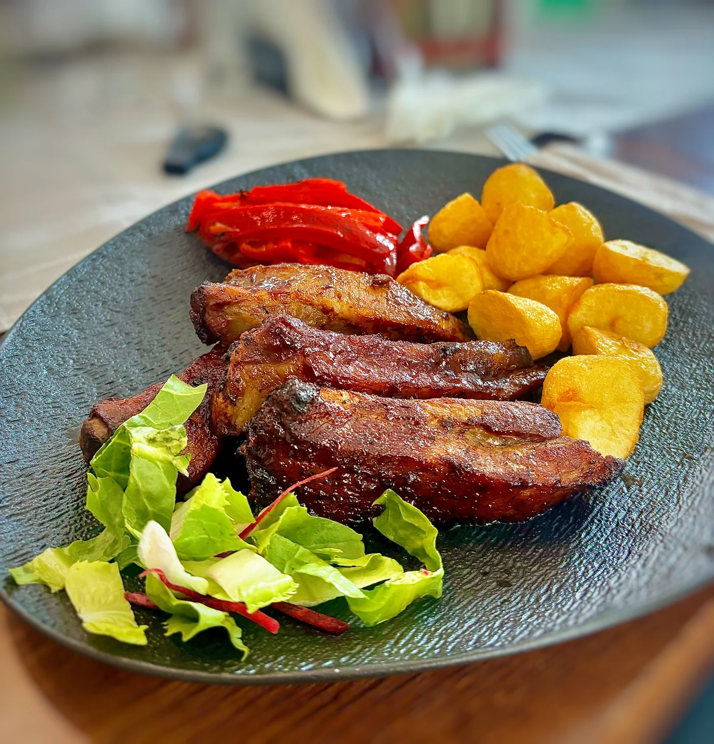Carne rumenită, cartofi aurii și legume pe un platou